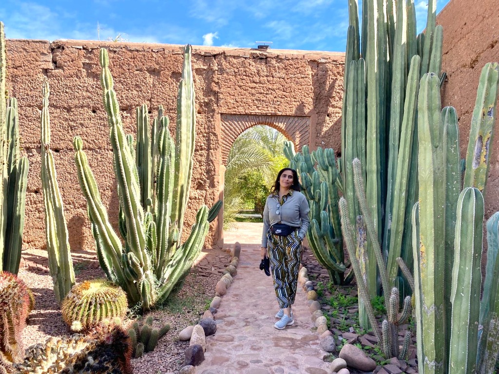 Niketa standing in a cactus garden under a blue sky